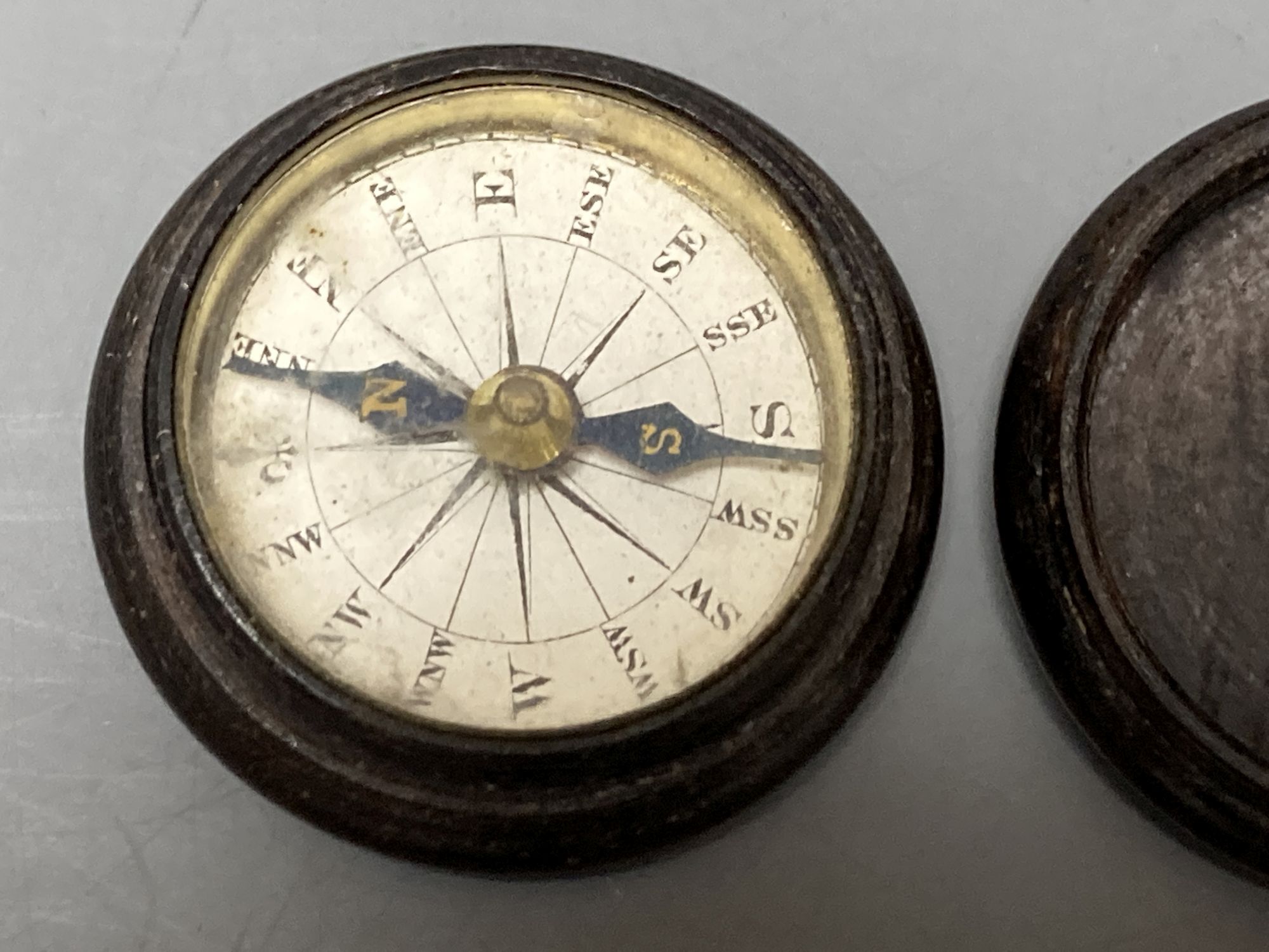 Five Tunbridge ware turned rosewood or mahogany boxes, late 19th/early 20th century, largest 5.8cm, the covers inlaid with tesserae or half square mosaic, one enclosing a compass, 3.8cm